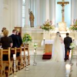 Ett brudpar står vid altaret i en kyrka framför sina gäster
