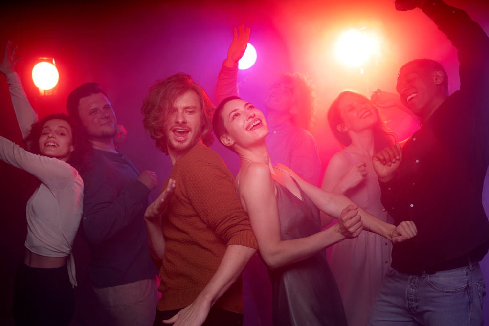 Män och kvinnor som dansar med färgglada lampor i bakgrunden