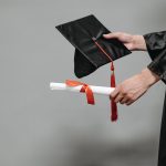 Person som håller en amerikansk studentmössa och studentpresent till henne